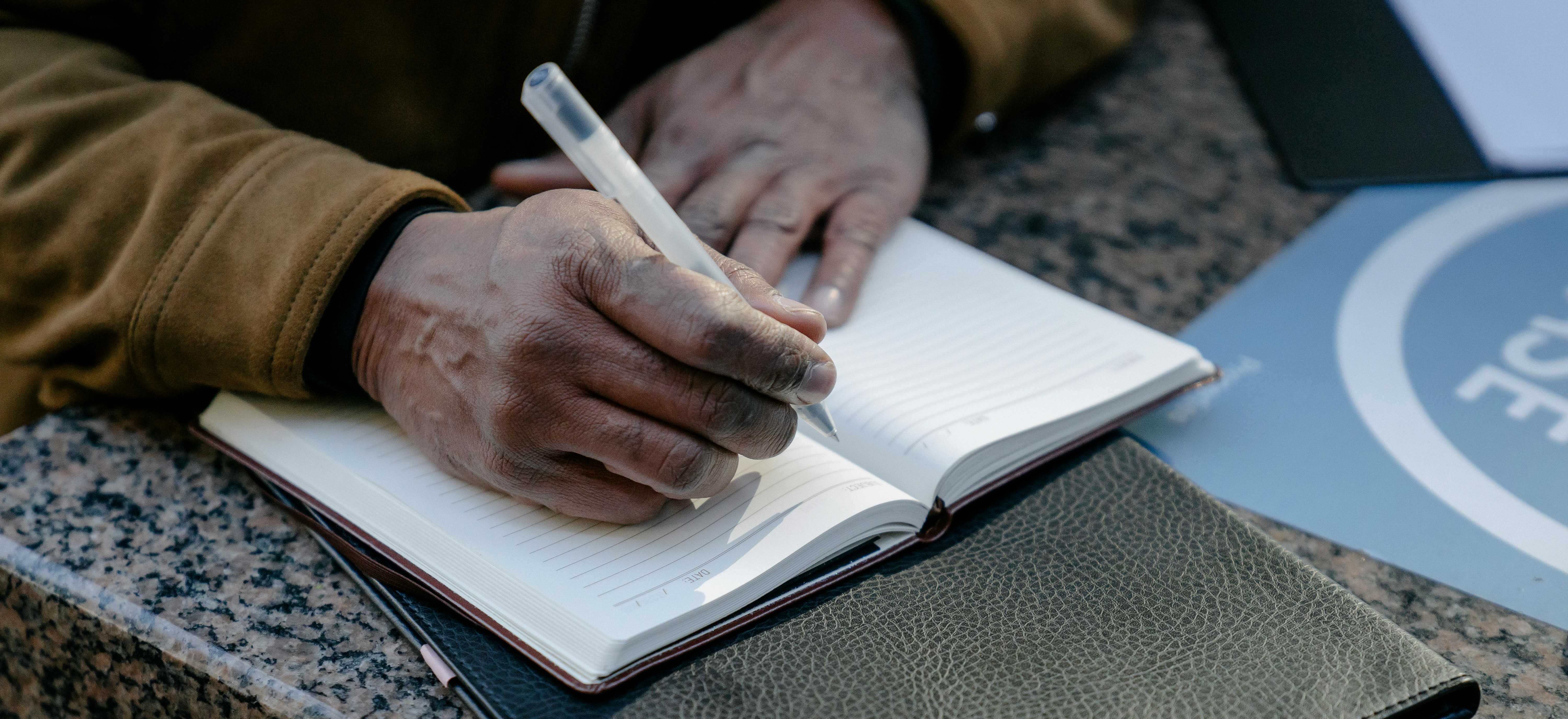 A person writing a thoughtful cover letter by hand.